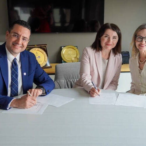 Marouane Kessentini, dean of GVSU’s College of Computing; Yuhila Alhatou, co-founder of The Mitten Project; and Jennifer Wangler, vice president of technology at The Right Place, smile while signing a Memorandum of Understanding.